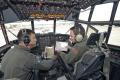 Maj. Brad Salmi (left), the chief of standardization/evaluation for the 61st Airlift Squadron at Little Rock AFB, Arkansas, and his copilot, Lt. Justin Pedone (right) go over the route of the final flight and the aircraft paperwork prior to the retirement ceremony for C-130E 61-2358 on 1 May 2012. The pair of fuzzy white dice, which had all the spots removed except for the six and one (61st Airlift Squadron), hanging from the overhead panel gave the flight a touch of nostalgia. 