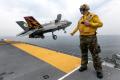 RAF Sqdn. Ldr. Jim Schofield takes off from the deck of USS Wasp one last time before making the flight back to the NAS Patuxent River, Maryland, home for BF-1. The bow waver ensures the deck is clear and signals the launch officer, or shooter, during the short takeoff.