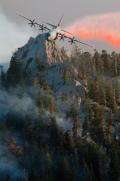 A C-130J Super Hercules crew assigned to the 146th Airlift Wing, the California Air National Guard unit at Channel Islands ANGS, releases fire retardant over the trees in the mountains above Palm Springs, California, on 19 July 2013. The 146th AW, one of three ANG and one Air Force Reserve Command units equipped with the Modular Airborne Firefighting System, or MAFFS, was activated to assist commercial air tankers in in fighting wildfires.