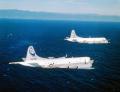 US Navy crews from Patrol Squadron 40 (VP-40) flying in a P-3C Update III and a P-3A from VP-65, a Navy Reserve Orion squadron, fly in low altitude formation somewhere off the West Coast, circa 1986.