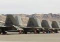 F-22 Raptors lined up on the ramp at Nellis AFB for Red Flag exercises.