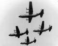 The Four Horsemen were the world's only four engine per aircraft demonstration team. Flying four C-130As in close formation, the team would perform a number of manuevers over a twenty-three minute airshow. The team would takeoff and fly much of the demonstration in the diamond formation. The two wingmen flew with barely ten feet of horizontal separation between their wingtips and the horizontal tail of the lead and at the same altitude. The slot pilot flew seven to ten feet behind and slightly above the lead. This show the diamond during a low altitude pass.