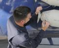 SSgt. Tommy Zurek, one of the Fat Albert loadmasters, signs the expended bottles after Bert’s airshow demonstration on 14 November 2009.