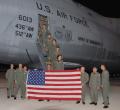 The augmented, joint active-duty Air Force/Air Force Reserve Command/Lockheed Martin C-5M Super Galaxy crew gather for a group shot prior to the world record flight on 13 September 2009. The American flag they are posing with had been flown in Afghanistan.